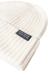 White ribbed beanie hat made of soft knit fabric, featuring a black label with "SOCCX ORIGINAL LIMITED EDITION" text.
