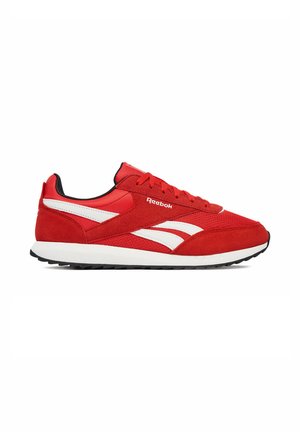 Scarpa da ginnastica Reebok rossa bassa con strisce laterali bianche, lacci rossi, fodera interna nera e suola bianca con battistrada nero testurizzato.