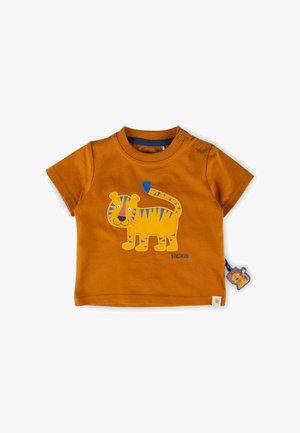 Maglietta color ruggine per bambino piccolo con applicazione di una tigre gialla a strisce blu e una piccola etichetta a forma di leone sul lato.