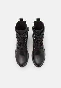 Botas de tobillo de cuero negro con un acabado suave, forro texturizado, cordones delanteros con acentos metálicos y cremallera lateral para un uso fácil.