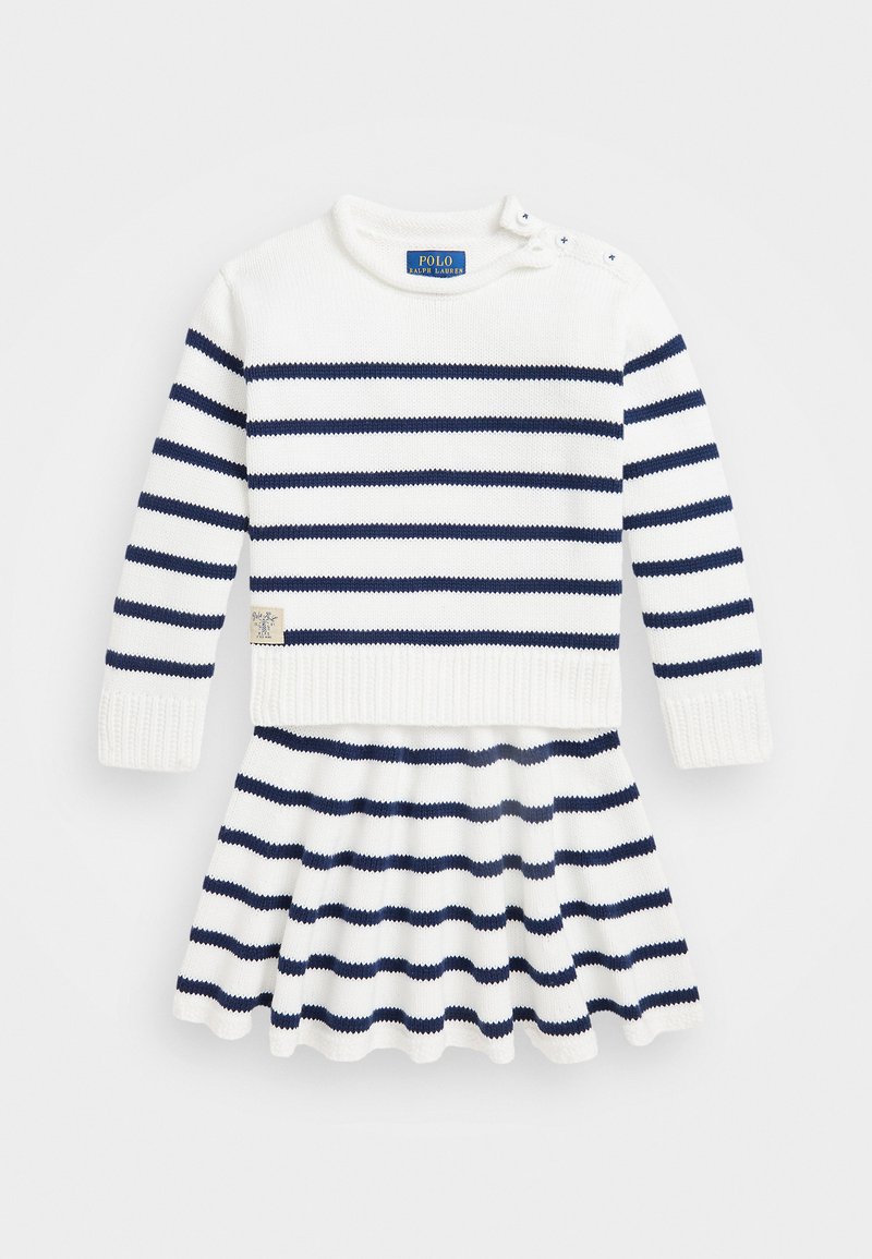 Λευκό πλεκτό φόρεμα με ναυτικές οριζόντιες ρίγες, ριγωτό λαιμό και μανσέτες, δύο κουμπιά στους ώμους και φουσκωτό μίντι με κρόσσι στο τελείωμα.