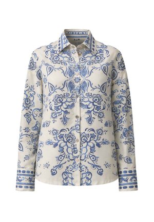 Blusa crema a maniche lunghe con intricati motivi floreali e paisley blu, davanti con bottoni, colletto appuntito e polsini decorati.