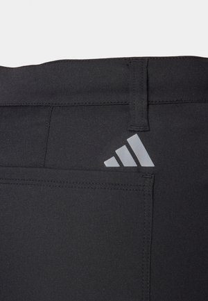 Sorte atletikbukser med en glat tekstur, der har en lomme og en grå Adidas-logo bagpå. Justerbar talje.