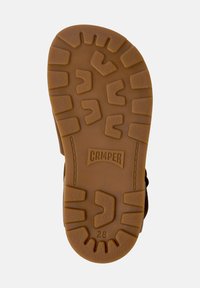 Brun gummisul med texturerat greppmönster. Har det märkta "CAMPER"-logotypen och storlek "28" präglat på den släta ytan.