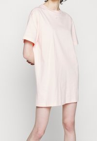 Světle růžové oversized tričko z bavlny, s kulatým výstřihem a krátkými rukávy. Malé logo Nike na hrudi.