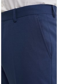 Granatowe spodni szyte na miarę, wykonane z tkaniny tkanej, z gładką teksturą, skośnymi kieszeniami bocznymi i płaskim paskiem w talii.