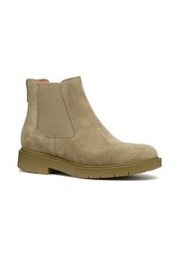 Stivaletti alla caviglia in suede color sabbia con pannelli laterali elasticizzati, punta rotonda e suola in gomma spessa e testurizzata. Presentano un linguetta sul retro per facilitare l'indossamento.