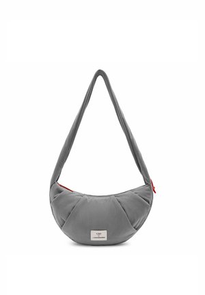 Grijze schoudertas in halve maanvorm met brede band, een rode ritstrekker en een klein wit merkembleem aan de voorkant in het midden.