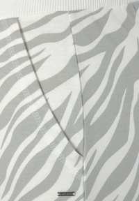Grahamund weißes Zebra-Print-Stoff mit einem gerippten Taillenbund. Es hat eine weiche Textur und sichtbare Nähte, mit einem kleinen silbernen Etikett mit der Aufschrift "LASCANA."