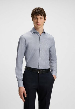 Hemd met knoopsluiting in een blauw-witte ruitpatroon, met lange mouwen, een kraag en een soepele textuur, gecombineerd met donkere broeken.