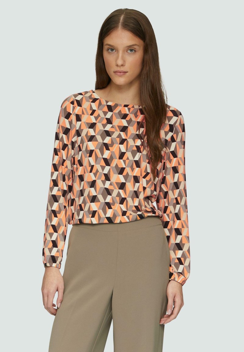 Langarmtop met een geometrisch patroon in oranje, bruin en beige. Gemaakt van een gladde stof met een ontspannen pasvorm en ronde halslijn.