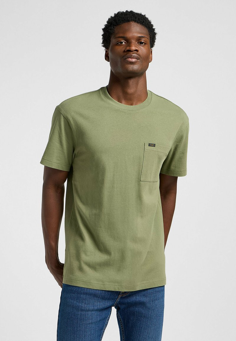 T-shirt in cotone verde oliva con scollatura rotonda, maniche corte e taschino sul petto con etichetta di marca.