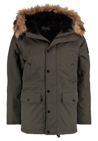 Parka verde oliva con cappuccio bordato in pelliccia, bottoni a pressione frontali, due tasche sul petto e cordino regolabile in vita.
