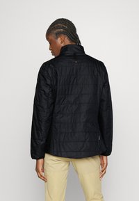 Sort quiltet jakke med høj krave, der har en enkelt rygslids og minimalistisk design. Stoffet har en glat, let skinnende tekstur.