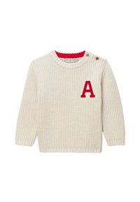 Pull crème tricoté avec un col rouge et une lettre "A" rouge brodée sur la poitrine, avec des fermetures à boutons latérales.