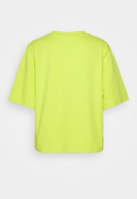 Neon žluté tričko s krátkým rukávem a volným střihem, má kulatý výstřih a jemnou bavlněnou strukturu. Žádné viditelné logo.