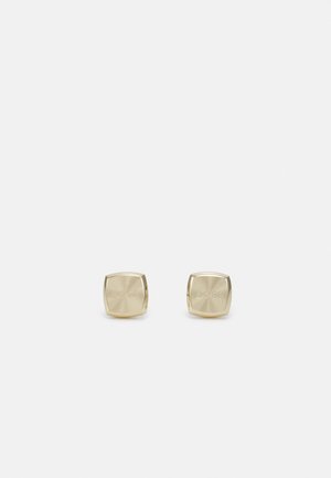 Coppia di piccoli gemelli quadrati in oro con superficie leggermente arrotondata e incisione sottile del marchio su sfondo bianco.
