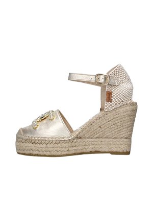 Espadrille con zeppa, superiore in finta pelle metallizzata oro, tacco in tessuto intrecciato, cinturino alla caviglia regolabile e decorazioni con gemme.