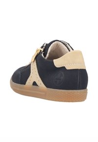 Black and beige sneaker with a textured leather upper, zip closure, and rubber sole. Features perforated accents and a logo detail.