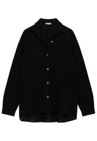 Chemise noire à col, à manches longues, avec une seule poche poitrine. Fabriquée en tissu texturé, avec des accents de boutons blancs.