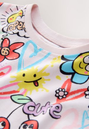 Short-sleeved shirt with a round neckline, made of soft cotton featuring a vibrant, multicolored graphic pattern of flowers, smiley faces, and text.