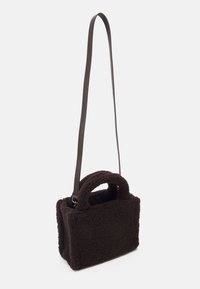 Bruine neppen schapenvacht tas met een rechthoekige vorm, korte ronde handvatten en een lange, dunne verstelbare strap. Textuur aan de buitenkant, geen zichtbare hardware.