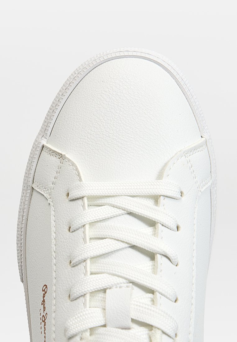 Sneaker bianco con tomaia in pelle liscia, lacci piatti, linguetta imbottita e cuciture laterali. Presenta una suola in gomma testurizzata e un dettaglio del logo.