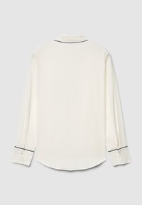 Long-sleeve white shirt with black piping along the collar and cuffs, featuring a smooth texture and rounded hemline.