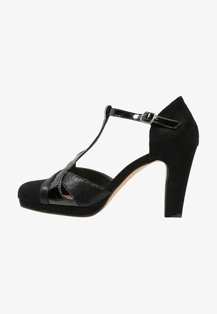 Chaussure à talon haut noire avec un design à T, combinant du daim mat et du vernis brillant, avec un panneau texturé et un avant à plateforme.