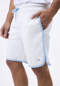 Lichtgrijze sportshorts gemaakt van zachte stof, met een blauwe trekkoord, contrasterende blauwe rand, zijzakken en een klein olifantenlogo.