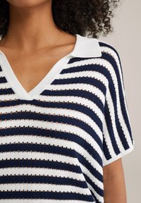 Ribade kõrgusega kampsun, millel on tumesinine ja valge triibuline muster, V-kujulise kaelusega, lühikeste varrukatega ning avatud kudumiga detailidega. Pehme tekstuur ja mugav lõige.