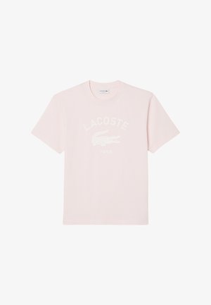 T-shirt rose clair à manches courtes avec col rond, arborant le texte blanc Lacoste et le logo crocodile centrés à l'avant.