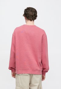 Φαρδιά μπλούζα φούτερ σε ξεθωριασμένο ροζ, μείγμα βαμβακιού. Στρογγυλή λαιμόκοψη, ριμπ μανσέτες και τελείωμα, απαλό ύφασμα, άνετη εφαρμογή, απλός σχεδιασμός.