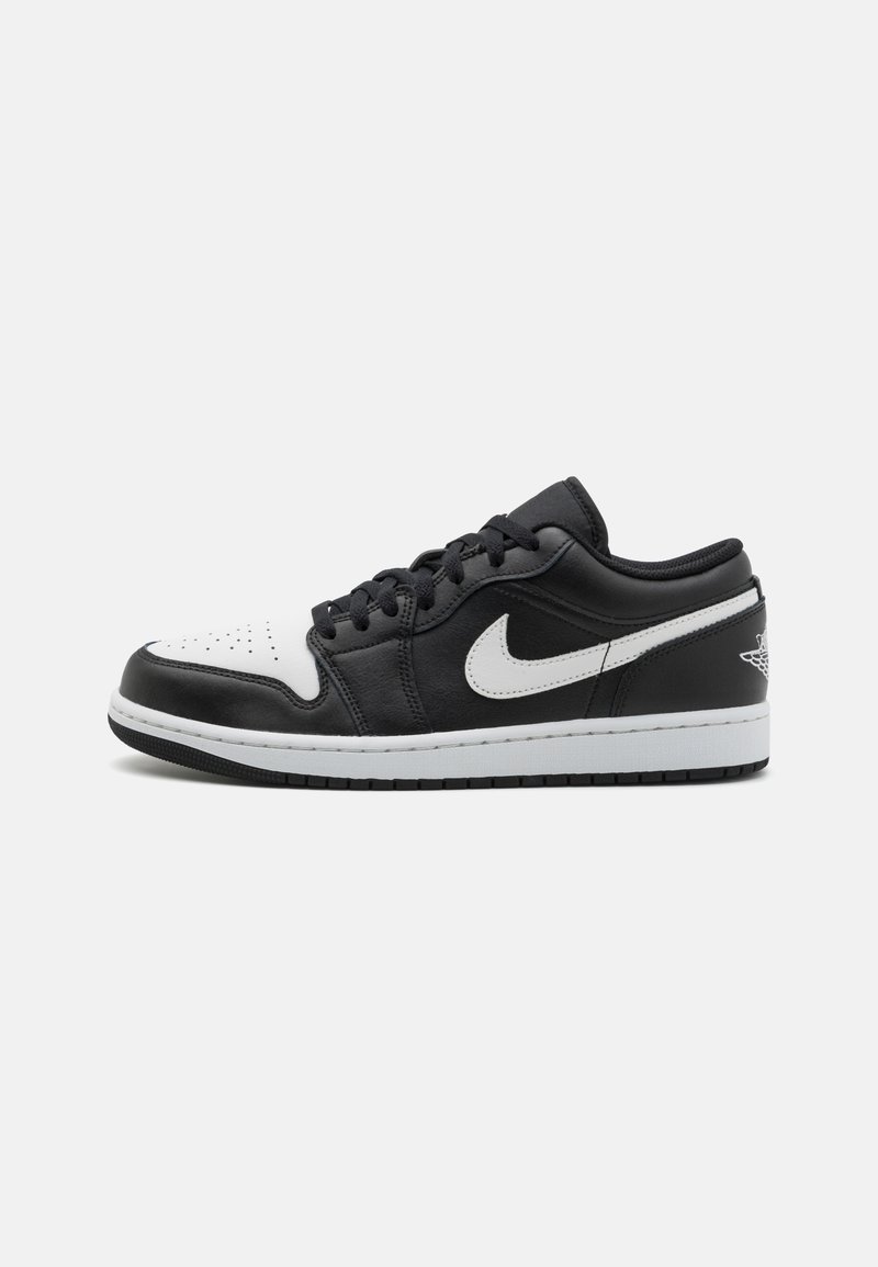 Black and white Nike Air Jordan shoes with leather upper, perforated toe, flat laces, and logo detail on the heel. Rubber sole.