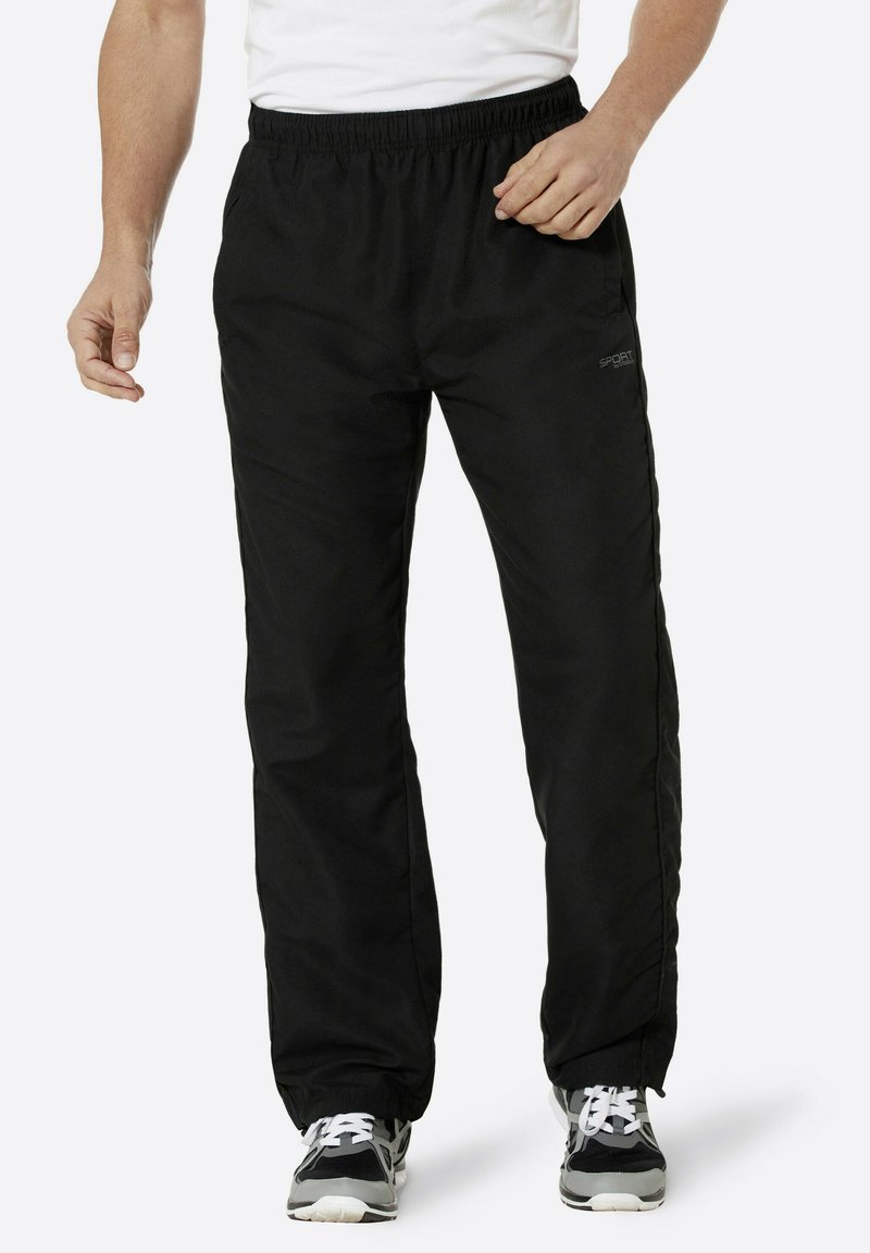 Schwarze Sporthosen verfügen über einen elastischen Bund, Seitentaschen und einen lockeren Sitz mit glatter Textur und dezentem Branding.