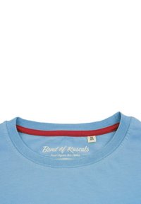 Ljusblå bomulls-T-shirt med en röd ribbad krage. Har en tryckt etikett "Band of Rascals" och en mjuk, slät yta.