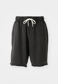 Svarte bomullsshorts med elastisk linning og hvit snor. Har sidelommer og ufinsede kanter med små glidelåsdetaljer.