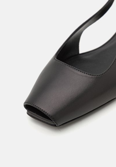 Svart öppen tå-sko med en slät läderfinish och en minimalistisk design; har en låg skärning framtill och ett smalt ankelsnöre.