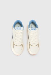 White mesh sneakers with light blue accents and tan detailing, featuring a rounded toe and flat lace closure. Brand name visible on tongue.