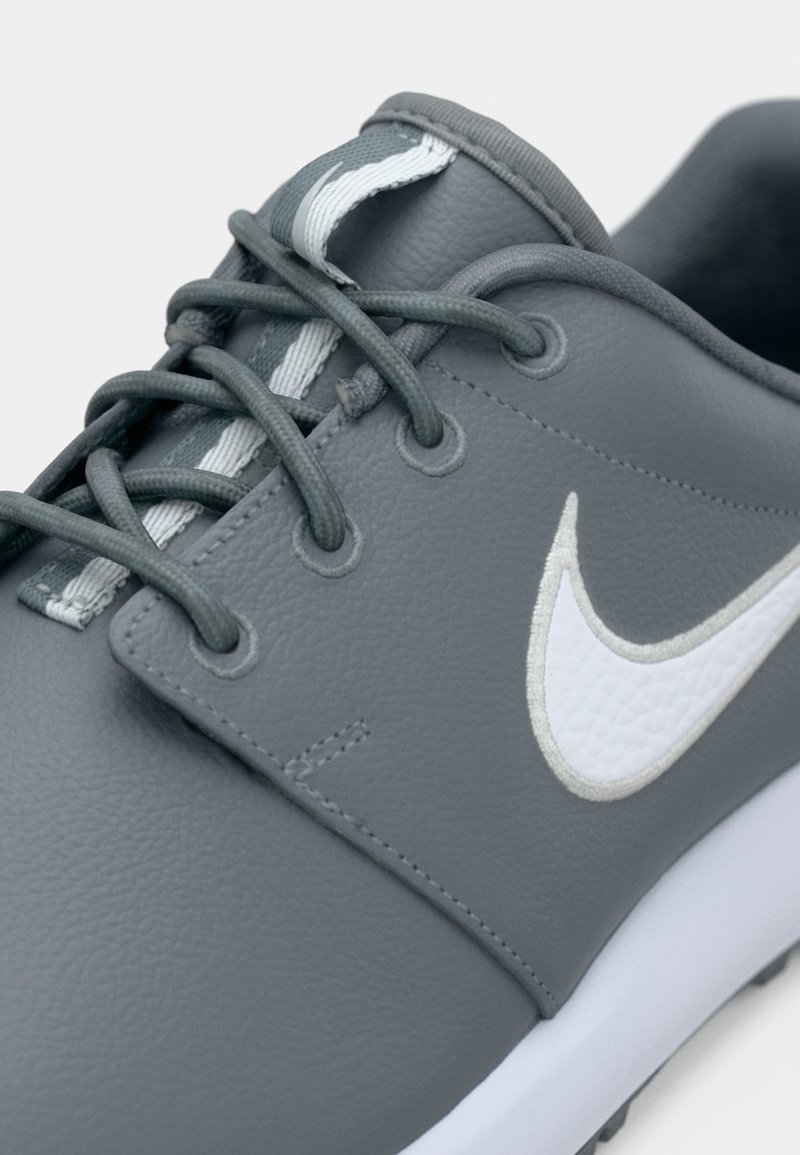 Grauer Ledersneaker mit grauen Schnürsenkeln und weißem Nike-Swoosh-Logo an der Seite, ausgestattet mit einer weißen Außensohle und gepolstertem Kragen.