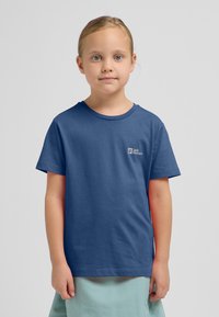 Blauwe katoenen T-shirt met korte mouwen, een ronde hals en een klein logo op de borst. Gladde textuur, eenvoudig ontwerp.