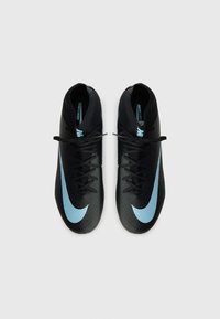 Black soccer cleats with a textured finish, featuring a light blue Nike swoosh and black laces. Designed for performance on the field.