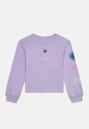 Lavendelfarvet cropped skjorte med lange ærmer med blå solgrafik, lyserød "ROXY" tekst og hvid signatur foran og på ærmet.