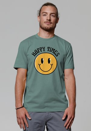 Green cotton t-shirt featuring a large yellow smiley face graphic with the text "HAPPY TIMES" above it. Short sleeves, crew neck design.