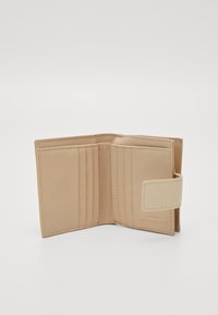 Beige lompakko, joka on valmistettu sileästä nahasta ja jossa on useita korttipaikkoja, napilla suljettava malli sekä kirjailtu brändiviittaus sisäpuolella.