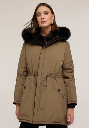 Parka isolata color beige con vita regolabile, cappuccio foderato in pelliccia nera, due grandi tasche frontali e chiusura con zip. Materiale liscio, design elegante.