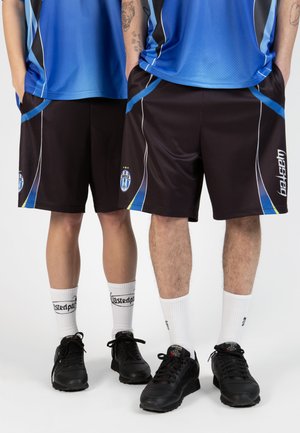 Black athletic shorts with blue and yellow accents, paired with black sneakers and white socks, worn by two people.