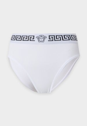 Hvide bikini-trusser med sort græsk nøglemønster og Medusa-hovedlogo på linningen mod en ensfarvet baggrund.