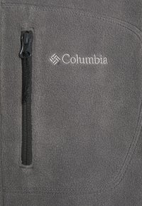 Hall hallitav kangas halli fliis, millel on lukuga tasku, kaunistatud valge broderitud Columbia logoga. Sile tekstuur ja puhast disain.