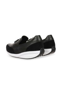 Zapatillas negras con un upper de cuero y ante, forma redondeada, suela de goma blanca y una correa de velcro. Presentan un respaldo texturizado y un branding mínimo.